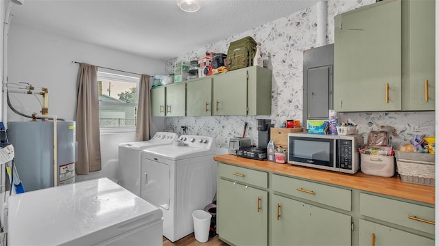 clothes washing area featuring washing machine and clothes dryer, electric panel, and water heater