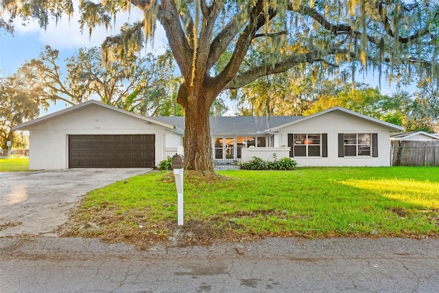 ranch-style house featuring a garage and a front lawn