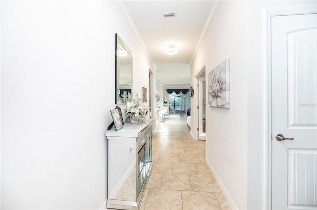 hall with light tile patterned floors and ornamental molding