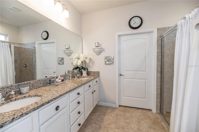 bathroom with a tile shower, tile patterned flooring, and vanity