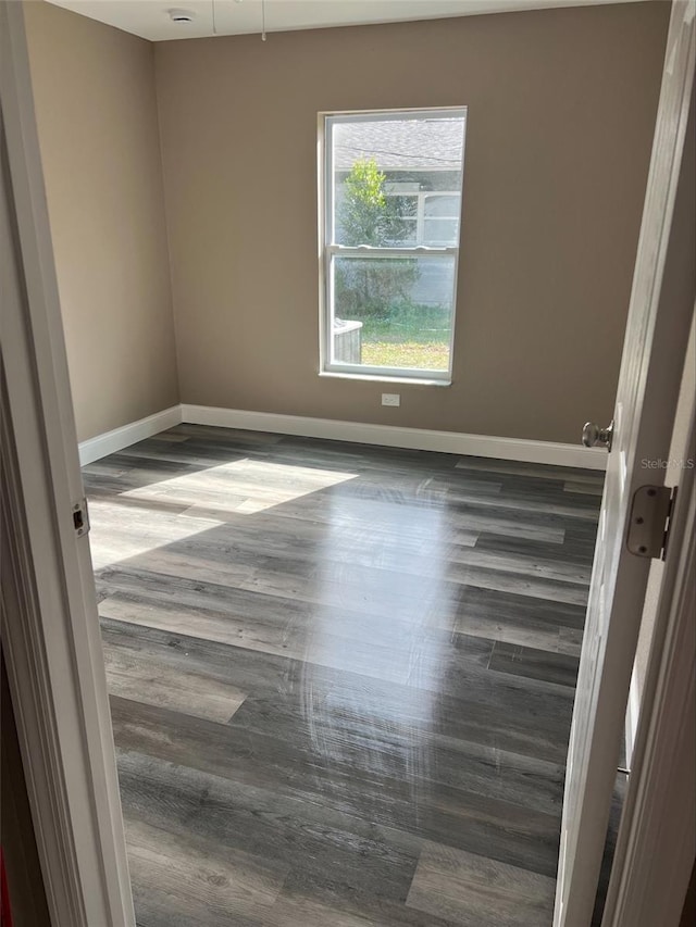 empty room with dark hardwood / wood-style flooring