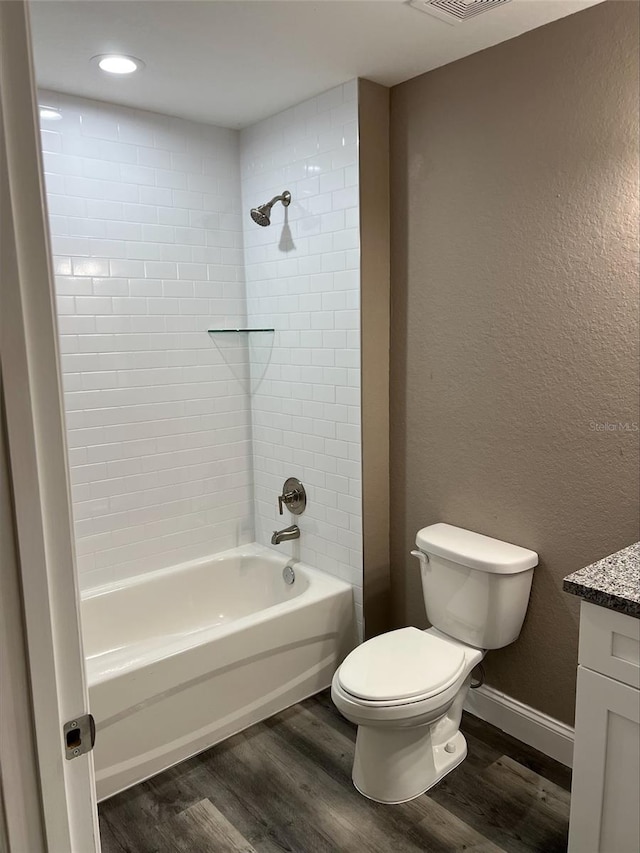 full bathroom featuring toilet, tiled shower / bath, wood-type flooring, and vanity