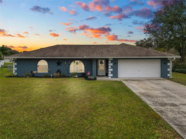 ranch-style house featuring a yard and a garage