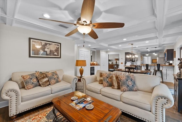 living room featuring beamed ceiling, ceiling fan with notable chandelier, and coffered ceiling