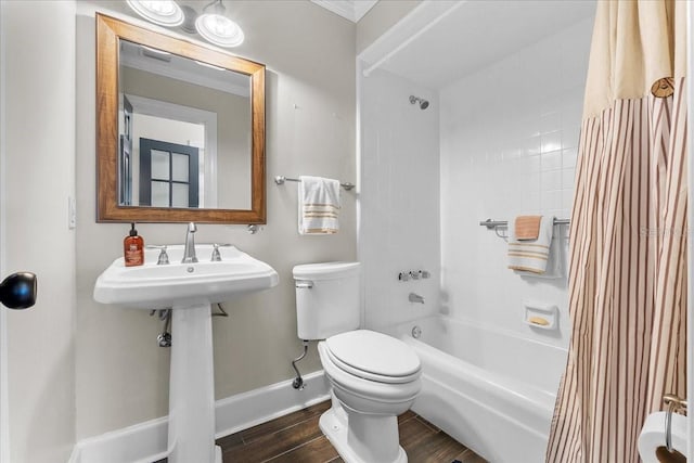 bathroom featuring toilet, shower / tub combo with curtain, and crown molding