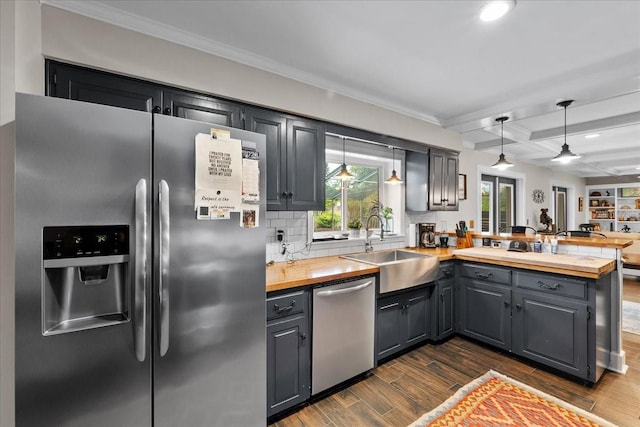 kitchen with sink, ceiling fan, appliances with stainless steel finishes, beam ceiling, and kitchen peninsula