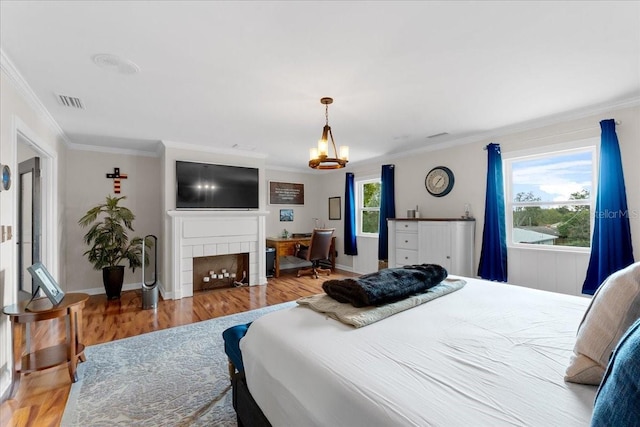 bedroom with multiple windows, crown molding, and light hardwood / wood-style floors