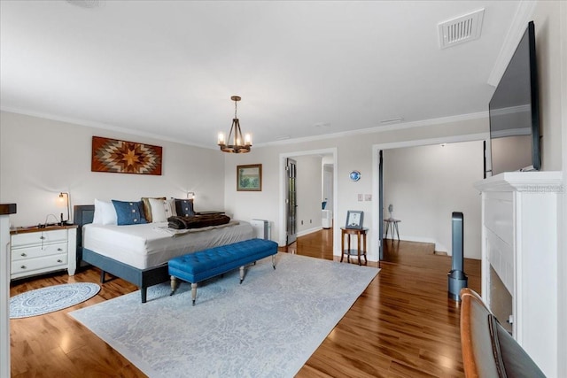 bedroom featuring dark hardwood / wood-style flooring, an inviting chandelier, and crown molding