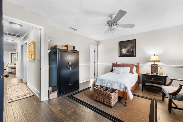 bedroom featuring ceiling fan, crown molding, and dark wood-type flooring