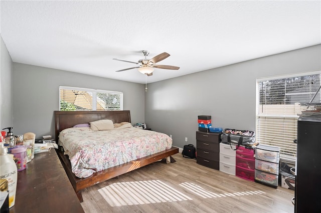 bedroom featuring a textured ceiling, light hardwood / wood-style floors, and ceiling fan