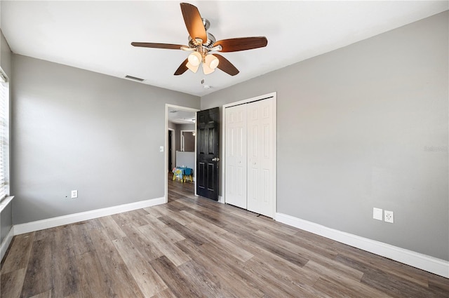 unfurnished bedroom with ceiling fan, a closet, and light hardwood / wood-style floors