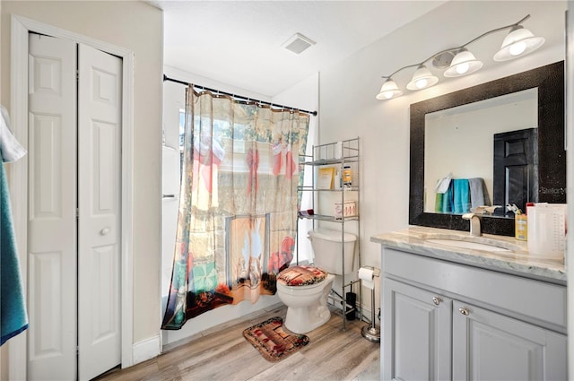 full bathroom featuring hardwood / wood-style floors, vanity, toilet, and shower / tub combo with curtain