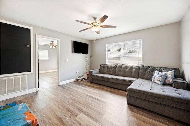 living room featuring ceiling fan, a healthy amount of sunlight, and light hardwood / wood-style flooring