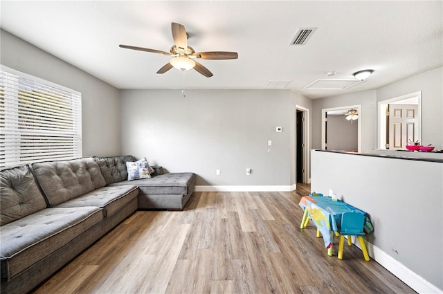 living room featuring ceiling fan and light hardwood / wood-style floors