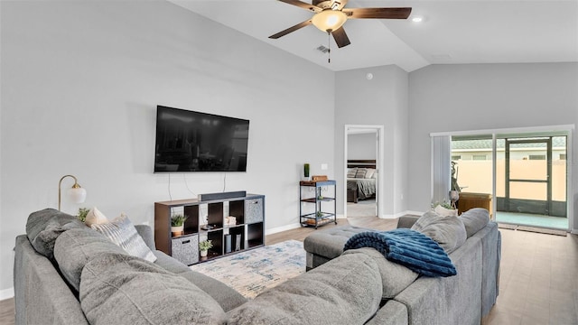 living room with ceiling fan, light hardwood / wood-style flooring, and vaulted ceiling