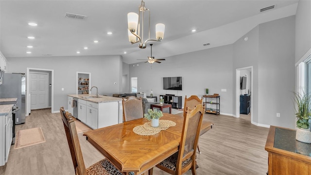 dining area with vaulted ceiling, ceiling fan, light wood-type flooring, and sink