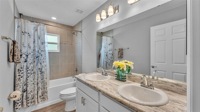 full bathroom featuring hardwood / wood-style floors, toilet, vanity, and shower / tub combo with curtain