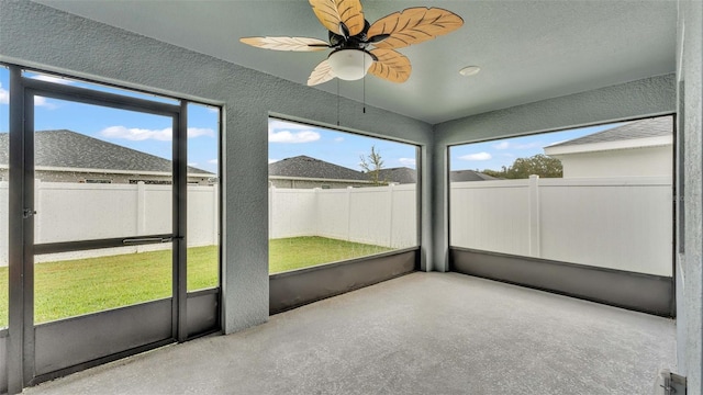 unfurnished sunroom with ceiling fan and a wealth of natural light