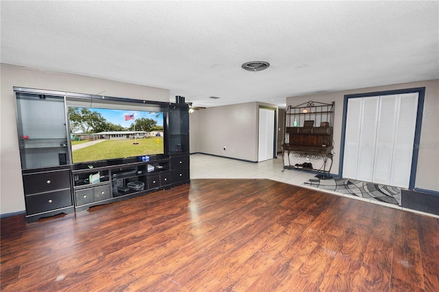 living room featuring wood-type flooring and a textured ceiling