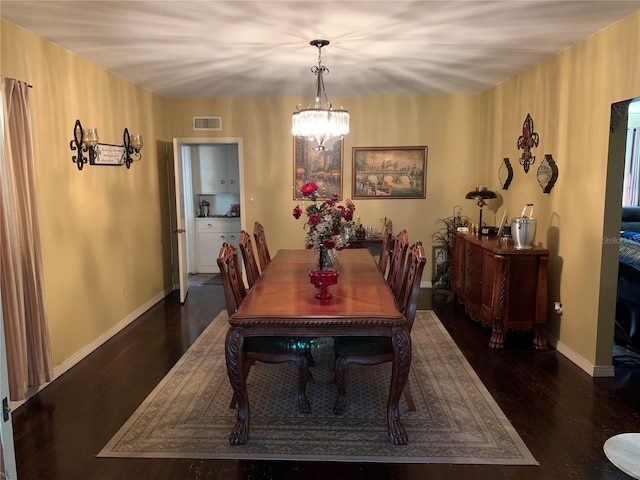 dining space with an inviting chandelier and dark wood-type flooring