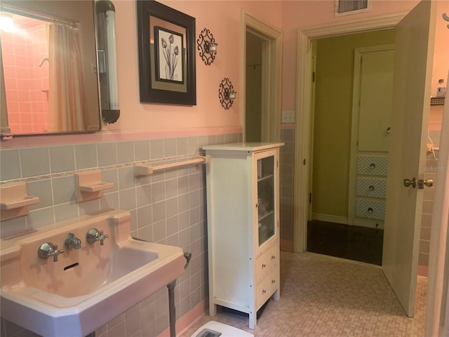 bathroom featuring sink, tile patterned floors, and tile walls