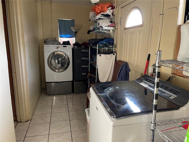 clothes washing area featuring washer and dryer and light tile patterned floors