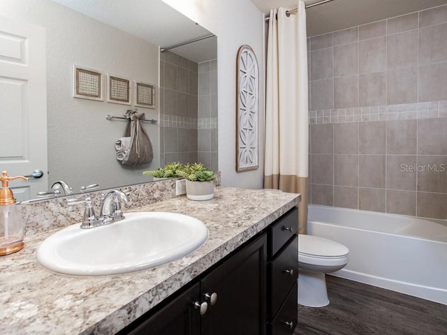 full bathroom with vanity, wood-type flooring, shower / bath combo, and toilet