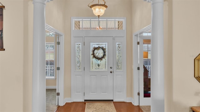 entrance foyer with light hardwood / wood-style flooring and ornate columns