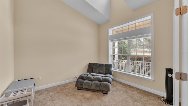 sitting room with vaulted ceiling and light carpet