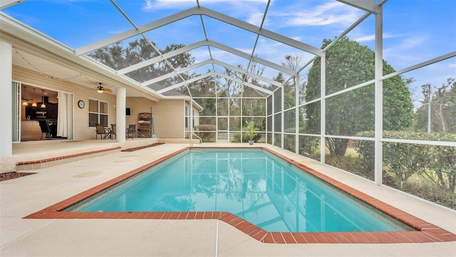 view of swimming pool with a patio area and glass enclosure