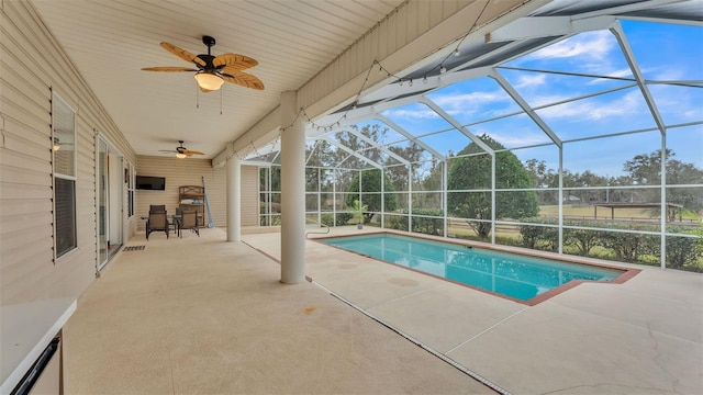 view of pool with a patio area, ceiling fan, and glass enclosure