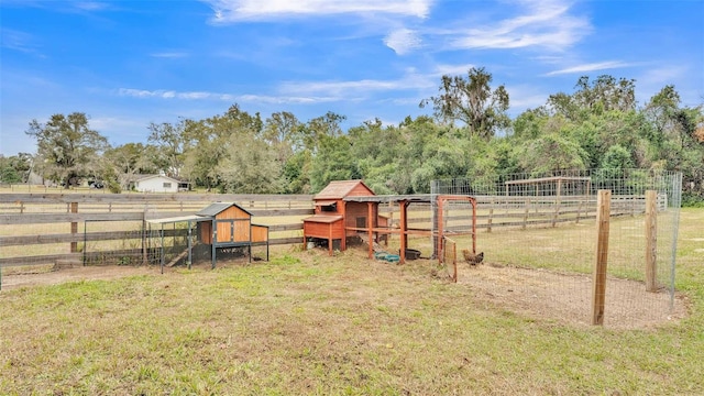 view of yard featuring an outdoor structure and a rural view