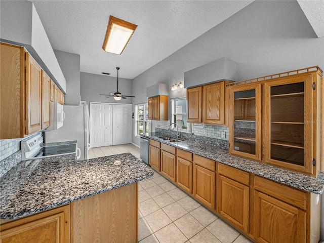 kitchen featuring stainless steel appliances, backsplash, light tile patterned flooring, and a sink