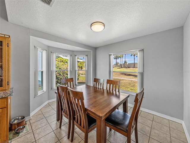 dining space featuring light tile patterned floors, visible vents, and a healthy amount of sunlight