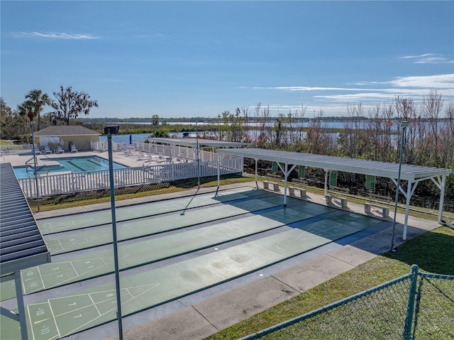 surrounding community with a patio area, fence, a swimming pool, and shuffleboard