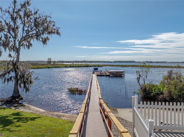 view of dock featuring a water view and fence