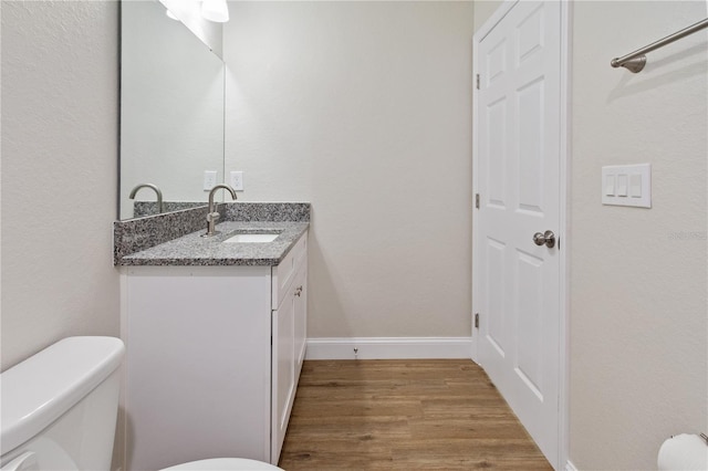 bathroom featuring vanity, toilet, and hardwood / wood-style floors