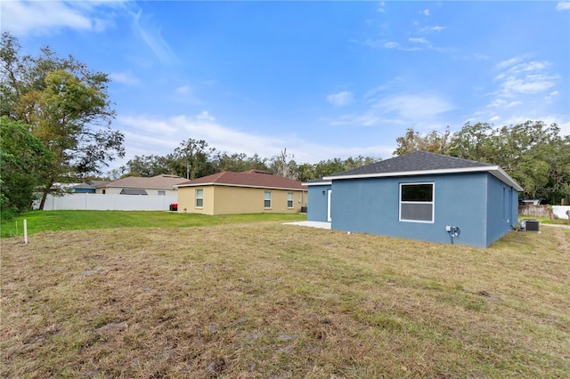 rear view of property with a lawn and cooling unit