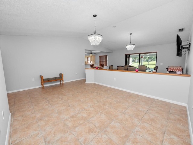 kitchen featuring a textured ceiling, hanging light fixtures, lofted ceiling, ceiling fan with notable chandelier, and light tile patterned flooring