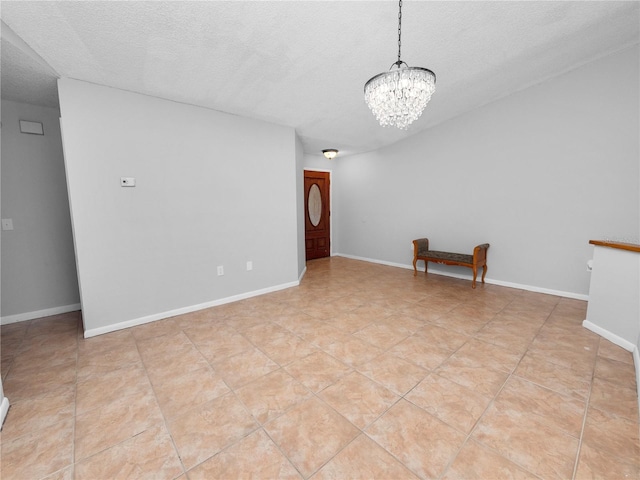 unfurnished room featuring a textured ceiling, light tile patterned floors, and a chandelier