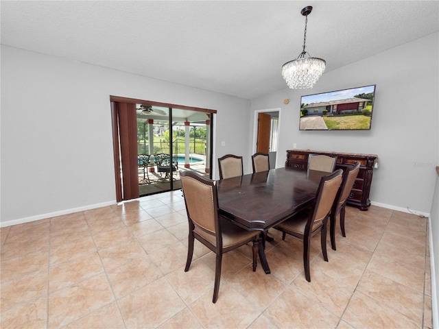 dining space featuring a textured ceiling, light tile patterned flooring, vaulted ceiling, and an inviting chandelier