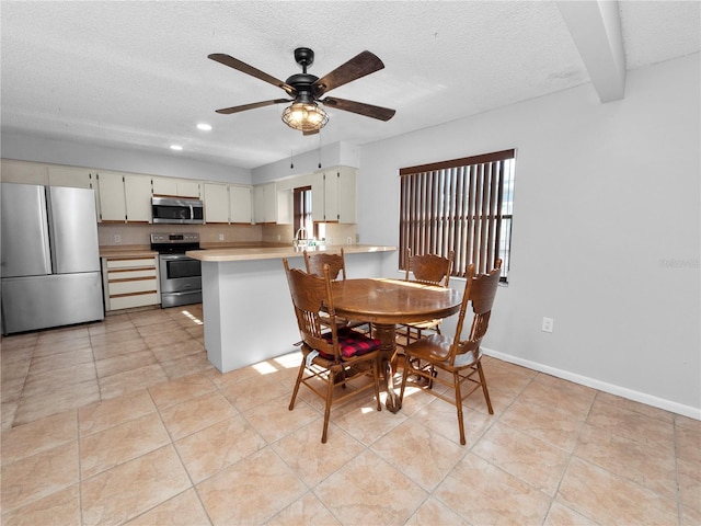 dining room with sink, a textured ceiling, ceiling fan, and light tile patterned floors