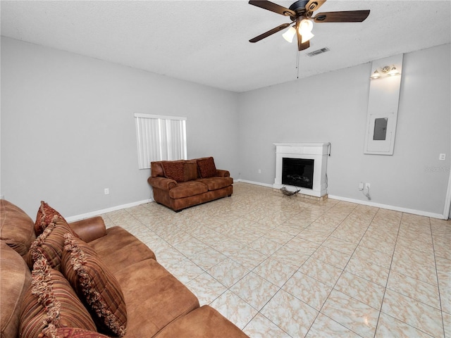 tiled living room with ceiling fan and a textured ceiling