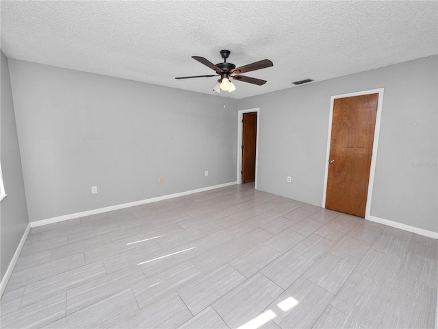 empty room featuring a textured ceiling and ceiling fan