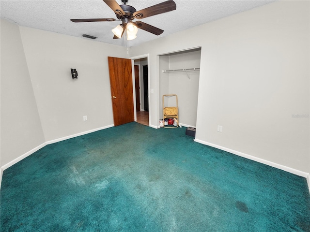 unfurnished bedroom featuring a closet, a textured ceiling, ceiling fan, and dark carpet