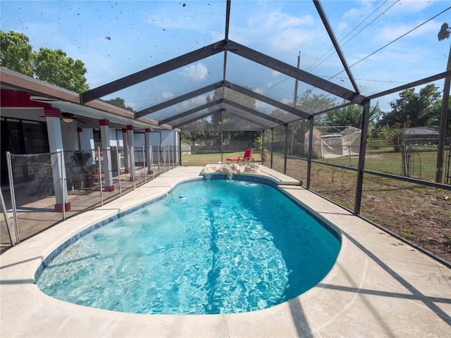 view of pool featuring ceiling fan, a patio, pool water feature, and glass enclosure