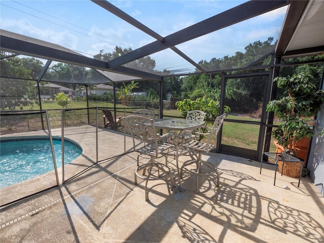 view of pool with a patio, glass enclosure, and a yard