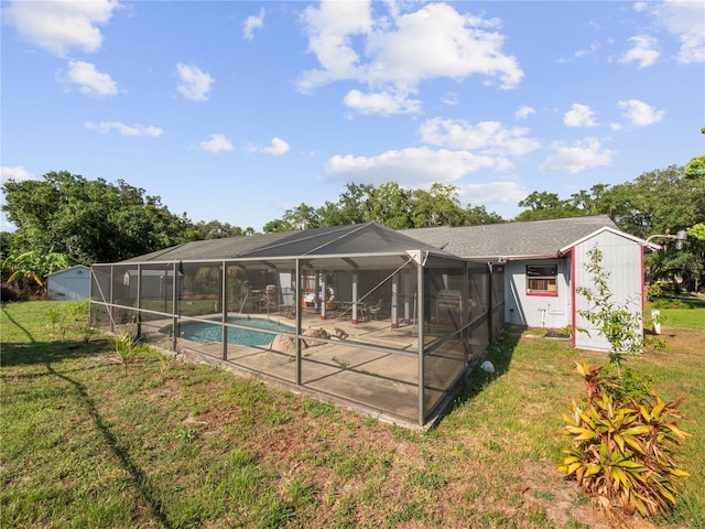 back of house with a lanai, a yard, and a patio