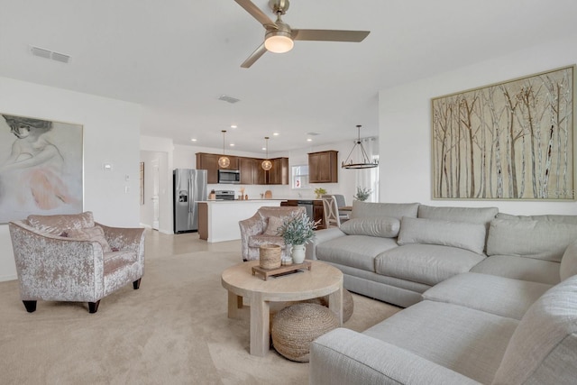 living room featuring ceiling fan with notable chandelier