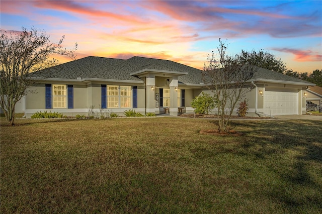 prairie-style home with a garage and a yard